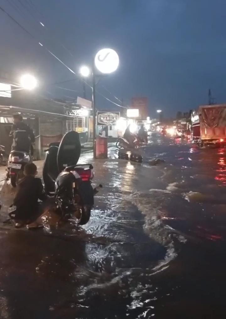 Banjir di Rawa Makmur Bengkulu menyebabkan banyak sepeda motor mogok. Warga turun tangan membantu pengendara di Jalan Kalimantan